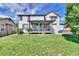 View of the home's backyard featuring a large lawn and covered patio at 12400 Village Cir, Brighton, CO 80603
