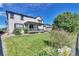 Spacious backyard with lush green grass, deck and mature trees at 12400 Village Cir, Brighton, CO 80603