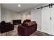 Comfortable basement space with plush seating, electric fireplace, and barn door entrance at 12400 Village Cir, Brighton, CO 80603