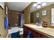 Cozy bathroom showcases a shower-tub combo, tile surround, and a single-sink vanity at 12400 Village Cir, Brighton, CO 80603