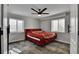 Bedroom featuring a ceiling fan, two windows, and neutral gray paint at 12400 Village Cir, Brighton, CO 80603
