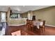 Open-concept dining area featuring hardwood floors and a table with seating for four adjacent to the kitchen area at 12400 Village Cir, Brighton, CO 80603