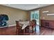 Dining room featuring hardwood floors, table and chairs with autumn themed tablecloth, and side buffet at 12400 Village Cir, Brighton, CO 80603