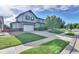 Two-story home showcasing a well-kept lawn, mature tree, and long driveway at 12400 Village Cir, Brighton, CO 80603