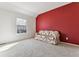 Cozy bedroom with red accent wall and floral sofa at 6415 Trailhead Rd, Highlands Ranch, CO 80130