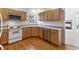 Bright kitchen with wood cabinets, hardwood floors, and modern appliances at 6415 Trailhead Rd, Highlands Ranch, CO 80130