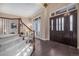 Elegant foyer with hardwood floors, a staircase, and a view into the living room at 9311 E Star Hill Trl, Lone Tree, CO 80124