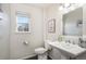 Clean half bathroom featuring a pedestal sink and modern fixtures at 19247 E Gunnison Pl # 104, Aurora, CO 80017