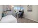 Sunlit bedroom with a comfortable bed, desk, and a view of the outdoors at 19247 E Gunnison Pl # 104, Aurora, CO 80017