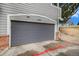 Attached one car garage door with address 104, alongside red painted parking space at 19247 E Gunnison Pl # 104, Aurora, CO 80017