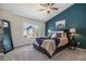 Comfortable main bedroom featuring a large bed, a blue accent wall and a large window at 19247 E Gunnison Pl # 104, Aurora, CO 80017