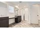 Modern bathroom with a glass shower, dark cabinets, double sink and marble tiled floor at 627 Nightsky St, Erie, CO 80516