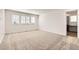 Bedroom featuring neutral carpet, three windows for plenty of natural light, and a bathroom doorway at 627 Nightsky St, Erie, CO 80516