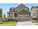 Two-story home with a covered porch, two-car garage, and well-maintained lawn and garden at 627 Nightsky St, Erie, CO 80516
