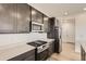 Kitchen with stainless steel appliances, gas range, quartz countertops and dark wood cabinets at 627 Nightsky St, Erie, CO 80516