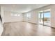 Bright living room with wood floors, large windows, and a sliding door to the outdoor space at 627 Nightsky St, Erie, CO 80516