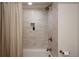 Bathroom with a tiled shower featuring bronze fixtures, a built-in niche, and a neutral color scheme at 768 W Larigo Ave, Littleton, CO 80120