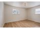 Cozy bedroom featuring hardwood floors and natural light from two windows at 768 W Larigo Ave, Littleton, CO 80120