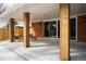 This covered patio features wood pillars, recessed lighting, and access to the home through sliding glass doors at 768 W Larigo Ave, Littleton, CO 80120