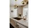 Close-up of the kitchen island showcases the marble countertop, gold fixtures, and stylish pendant lights at 768 W Larigo Ave, Littleton, CO 80120