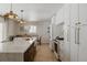 Elegant kitchen featuring a large marble island, modern lighting fixtures, and stainless steel appliances at 768 W Larigo Ave, Littleton, CO 80120