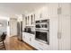 Modern kitchen featuring stainless steel appliances, white cabinets, and hardwood floors at 7440 W 94Th Pl, Westminster, CO 80021