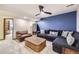 Relaxing living room features a large sectional sofa, wicker coffee table, and stylish blue accent wall at 7440 W 94Th Pl, Westminster, CO 80021