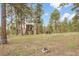 Wooded backyard with playhouse and climbing wall provides endless outdoor fun and adventure at 29266 S Sunset Trl, Conifer, CO 80433