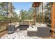 Relax on this outdoor deck with wicker seating and a beautiful view of the surrounding forest at 29266 S Sunset Trl, Conifer, CO 80433