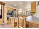 Open kitchen features stainless appliances, custom wood cabinetry, and eat-in breakfast bar at 29266 S Sunset Trl, Conifer, CO 80433