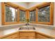 Kitchen sink under corner windows with forest views, providing natural light and a connection to nature at 29266 S Sunset Trl, Conifer, CO 80433