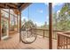Cozy outdoor space with a swing chair on a covered porch, offering a relaxing view of the forest and mountains at 29266 S Sunset Trl, Conifer, CO 80433