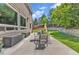 Backyard patio with outdoor dining, a green lawn, mature trees, and well-maintained landscaping at 2938 S Zeno Way, Aurora, CO 80013