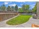 Backyard with a green lawn, tall trees, and a wooden fence providing a quiet outdoor space at 2938 S Zeno Way, Aurora, CO 80013