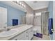 Well-lit bathroom features a large mirror, vanity, and shower-tub combination with floral shower curtain at 2938 S Zeno Way, Aurora, CO 80013