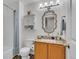 Bathroom with marble vanity, storage cabinet, tub with light blue shower curtain, and modern lighting fixture at 9758 Laredo St # 35B, Commerce City, CO 80022
