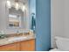 Cozy bathroom featuring single sink, granite countertop, and blue accent wall at 9758 Laredo St # 35B, Commerce City, CO 80022