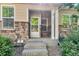 Townhome entrance featuring stone accents, a covered entryway, and well-maintained landscaping at 9758 Laredo St # 35B, Commerce City, CO 80022