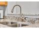 Close-up of a kitchen sink with stainless steel faucet and granite countertops at 9758 Laredo St # 35B, Commerce City, CO 80022