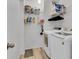 Efficient laundry room with side-by-side washer and dryer, complemented by functional shelving for ample storage at 9758 Laredo St # 35B, Commerce City, CO 80022