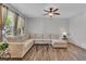 Bright living room with modern ceiling fan, neutral sofa, and hardwood flooring at 9758 Laredo St # 35B, Commerce City, CO 80022
