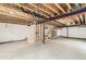 Unfinished basement with exposed beams, a window allowing natural light, and utilities ready to be finished at 4495 Windmill Dr, Brighton, CO 80601