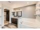 This bathroom offers double sinks, a soaking tub, and access to a walk-in closet with custom shelving at 4495 Windmill Dr, Brighton, CO 80601