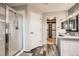 Bright bathroom features a glass-enclosed shower and leads into a closet with custom shelving at 4495 Windmill Dr, Brighton, CO 80601