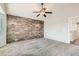 Spacious bedroom featuring a wood accent wall, ceiling fan, and carpeted floors at 4495 Windmill Dr, Brighton, CO 80601