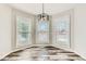 Dining area features three windows providing ample natural light, complemented by wood-look floors at 4495 Windmill Dr, Brighton, CO 80601