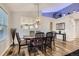 Open dining room with wood floors, elegant light fixture, and sight lines into the kitchen at 4495 Windmill Dr, Brighton, CO 80601