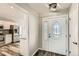 Bright foyer with wood floors, decorative front door, and a view of the kitchen at 4495 Windmill Dr, Brighton, CO 80601