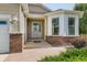 Welcoming front entrance with brick details, covered porch, and landscaped surroundings at 4495 Windmill Dr, Brighton, CO 80601