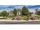 Charming home featuring a beautifully landscaped front yard with mature trees and colorful flower beds for curb appeal at 4495 Windmill Dr, Brighton, CO 80601